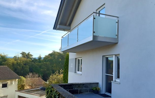 Metallbau Hofmann - Balkongeländer in Edelstahl mit Glasfüllung und Verblendung der Betonkannte mit Edelstahlblech